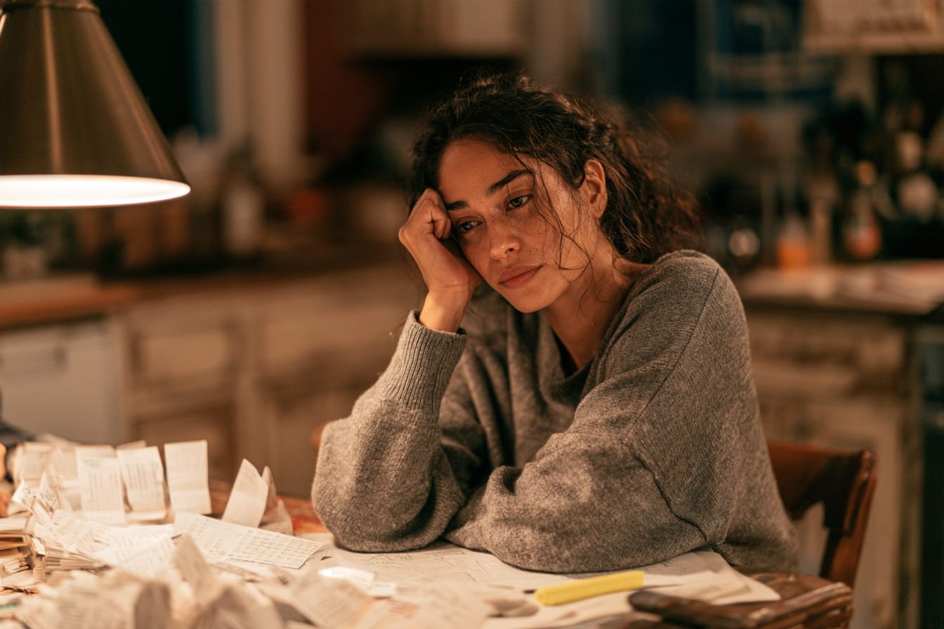Overwhelmed student studying alone at a kitchen table